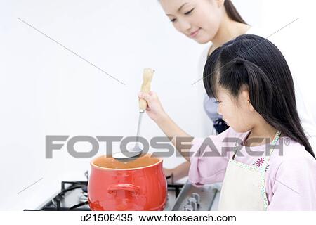 Stock Photography - Mother and daughter cooking soup. Fotosearch