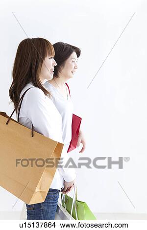 Mother and daughter holding shopping bags View Large Photo Image Picture - Mother and daughter holding shopping bags. Fotosearch