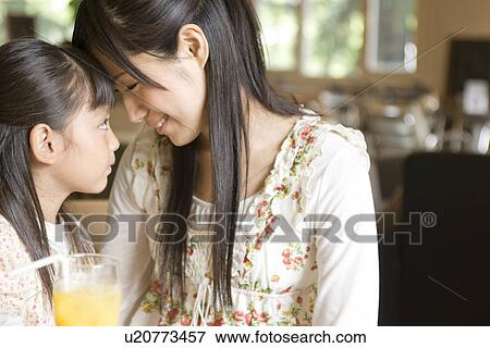 Stock Photo - Mother and daughter spending time together at a cafe. Fotosearch