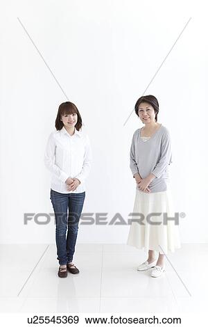 Stock Photo - Mother and daughter standing next to each other. Fotosearch