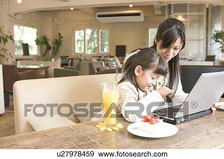 Mother and daughter using laptop at a cafe View Large Photo Image Stock Photo - Mother and daughter using laptop at a cafe. Fotosearch