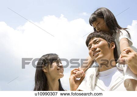 Mother and father carrying daughter on his shoulders View Large Photo Image Stock Photo - Mother and father carrying daughter on his shoulders. Fotosearch