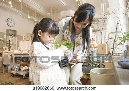 Stock Photograph - Mother and little girl shopping in homeware store together. Fotosearch