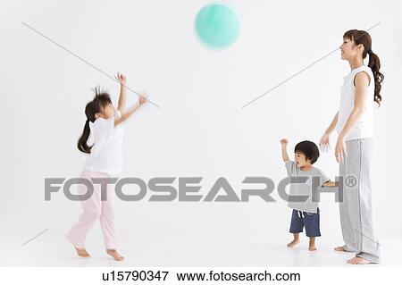 Mother and two children playing with a ball View Large Photo Image Stock Photo - Mother and two children playing with a ball. Fotosearch