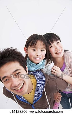 Stock Photograph - Mother, father and daughter getting a piggyback. Fotosearch