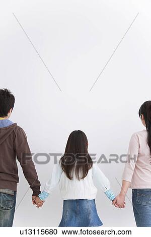 Stock Image - Mother, father and daughter holding hands. Fotosearch