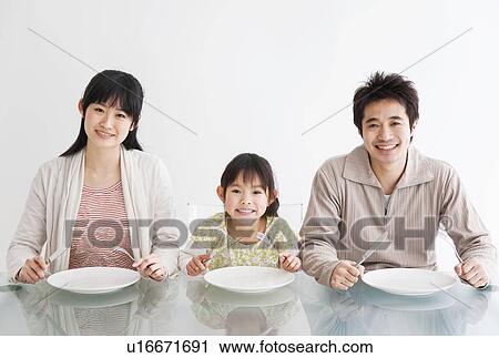 Mother, father and daughter sitting at table waiting for food View Large Photo Image Stock Image - Mother, father and daughter sitting at table waiting for food. Fotosearch