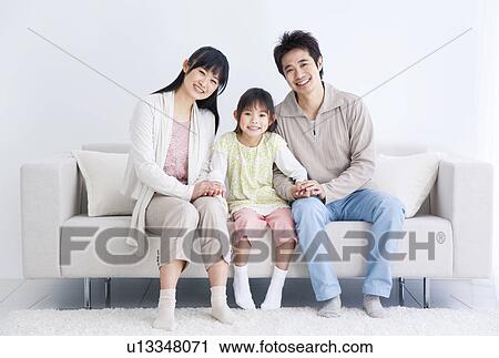 Mother, father and daughter sitting on couch View Large Photo Image Stock Image - Mother, father and daughter sitting on couch. Fotosearch