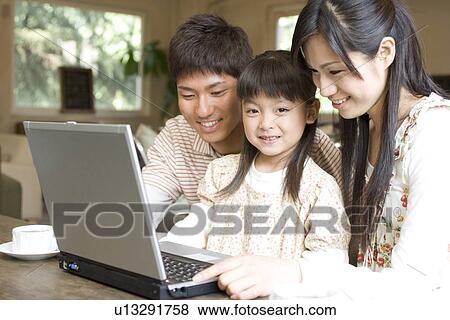 Mother, father and daughter using laptop at a cafe View Large Photo Image Stock Photo - Mother, father and daughter using laptop at a cafe. Fotosearch