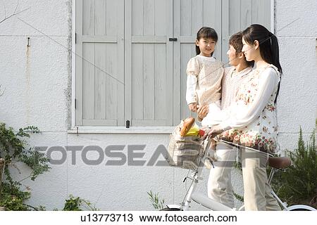 Mother, father and daughter walking with groceries in bicycle basket View Large Photo Image Stock Image - Mother, father and daughter walking with groceries in bicycle basket. Fotosearch