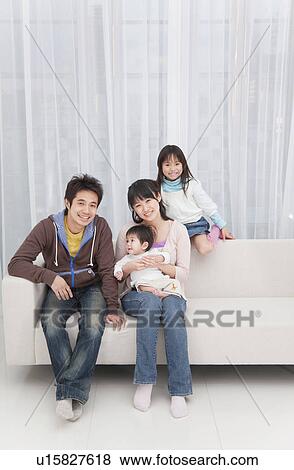 Mother, father, daughter and baby boy sitting on couch View Large Photo Image Stock Photo - Mother, father, daughter and baby boy sitting on couch. Fotosearch
