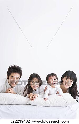 Mother, father daughter and crying baby son lying on bed View Large Photo Image Stock Image - Mother, father daughter and crying baby son lying on bed. Fotosearch