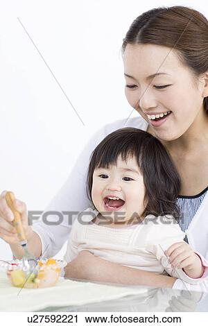 Mother feeding baby daughter fruit salad View Large Photo Image Stock Image - Mother feeding baby daughter fruit salad. Fotosearch