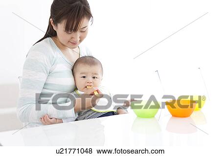 Stock Photo - Mother feeding her baby. Fotosearch
