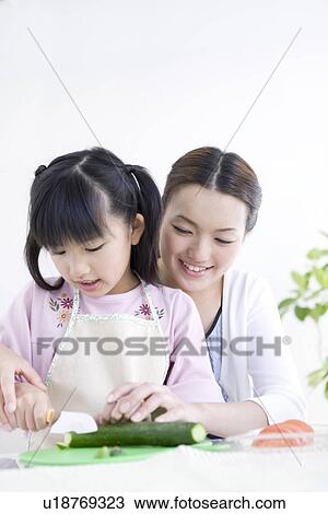 Mother helping daughter to slice zucchini View Large Photo Image Stock Image - Mother helping daughter to slice zucchini. Fotosearch