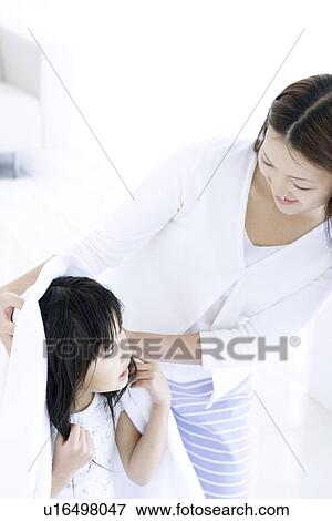 Stock Photo - Mother helping to dry daughter's hair with a towel. Fotosearch
