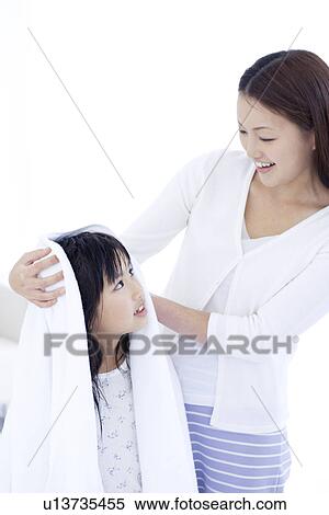 Stock Photography - Mother helping to dry daughter's hair with a towel. Fotosearch