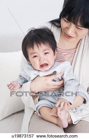 Stock Photo - Mother holding crying baby boy. Fotosearch