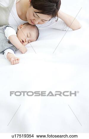 Picture - Mother lying with her sleeping baby. Fotosearch