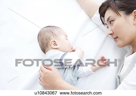 Stock Photo - Mother lying with her sleeping baby. Fotosearch