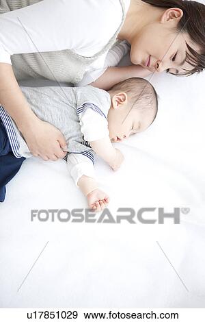 Stock Photo - Mother lying with her sleeping baby. Fotosearch