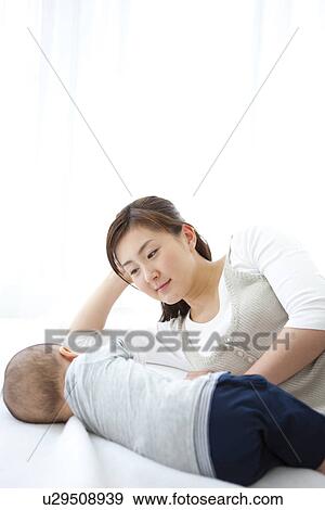 Mother lying with her sleeping baby View Large Photo Image Stock Photo - Mother lying with her sleeping baby. Fotosearch