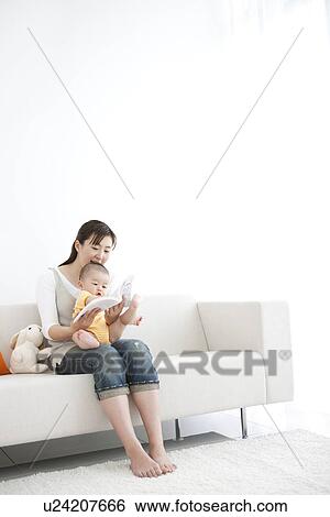 Stock Photograph - Mother reading a book to her baby. Fotosearch