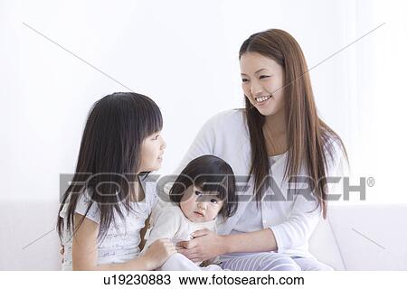 Mother sitting with her two daughters View Large Photo Image Stock Image - Mother sitting with her two daughters. Fotosearch