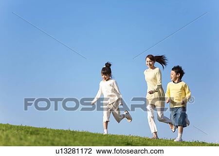 Mother with her young son and daughter playing at the park against a clear blue sky View Large Photo Image Stock Image - Mother with her young son and daughter playing at the park against a clear blue sky. Fotosearch