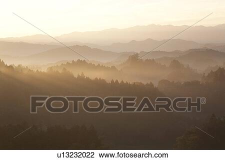 Stock Image - Mountain range surrounded by fog. Fotosearch