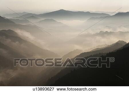 Stock Photo - Mountain range surrounded by fog. Fotosearch