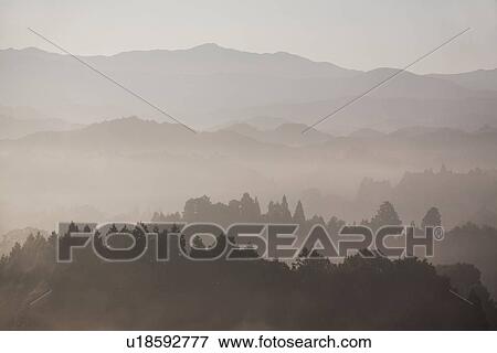 Stock Photo - Mountain range surrounded by fog. Fotosearch
