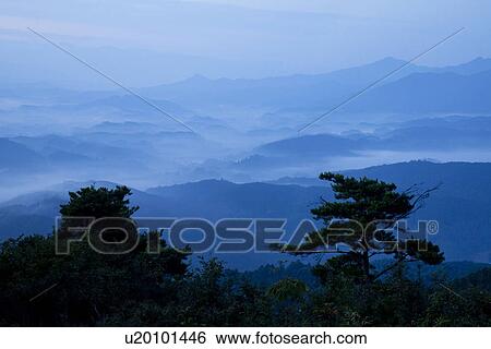 Stock Photograph - Mountain range surrounded by fog. Fotosearch