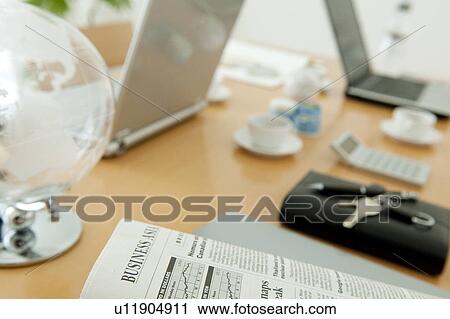 Stock Image - Office with newspaper, globe and laptops on desk. Fotosearch