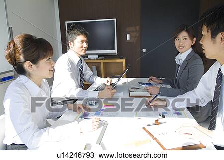Stock Image - Office workers in a meeting. Fotosearch