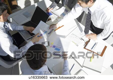 Stock Image - Office workers in a meeting. Fotosearch