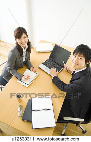 Stock Image - Office workers smiling in suits. Fotosearch