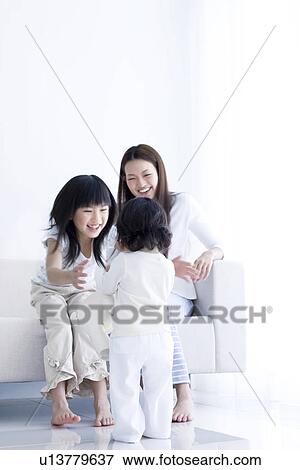 One year old girl walking towards mother and sister View Large Photo Image Stock Photo - One year old girl walking towards mother and sister. Fotosearch
