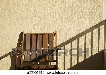 Stock Image - Outdoor chair against a wall. Fotosearch