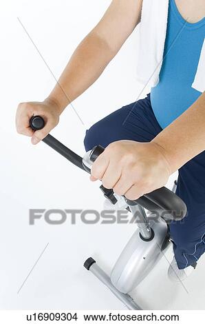 Picture - Overweight man exercising on a gym machine. Fotosearch