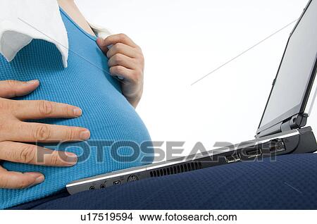 Overweight man in gym gear using a laptop View Large Photo Image Picture - Overweight man in gym gear using a laptop. Fotosearch