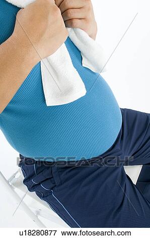 Stock Photo - Overweight man in gym gear using a laptop. Fotosearch