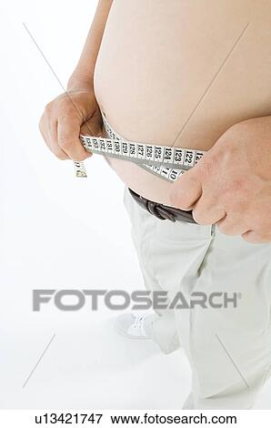 Stock Photo - Overweight man measuring his pot belly. Fotosearch