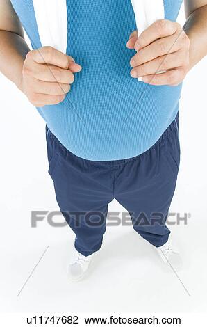 Stock Image - Overweight man with a pot belly in gym gear. Fotosearch