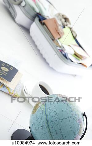 Picture - Packed suitcase lying open and a globe. Fotosearch