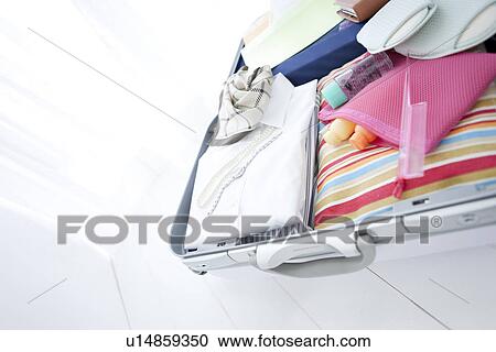 Stock Image - Packed suitcase lying open. Fotosearch