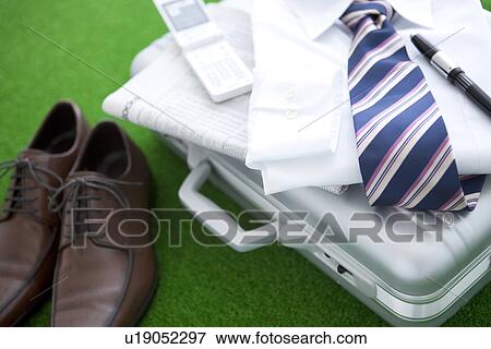 Stock Photo - Pair of shoes and a shirt next to a suitcase. Fotosearch