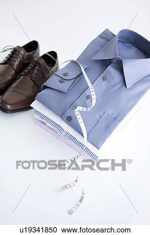 Stock Image - Pair of shoes and folded shirts. Fotosearch