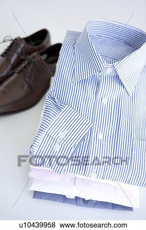 Pair of shoes and folded shirts View Large Photo Image Stock Photo - Pair of shoes and folded shirts. Fotosearch