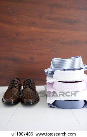 Pair of shoes and folded shirts View Large Photo Image Stock Photograph - Pair of shoes and folded shirts. Fotosearch